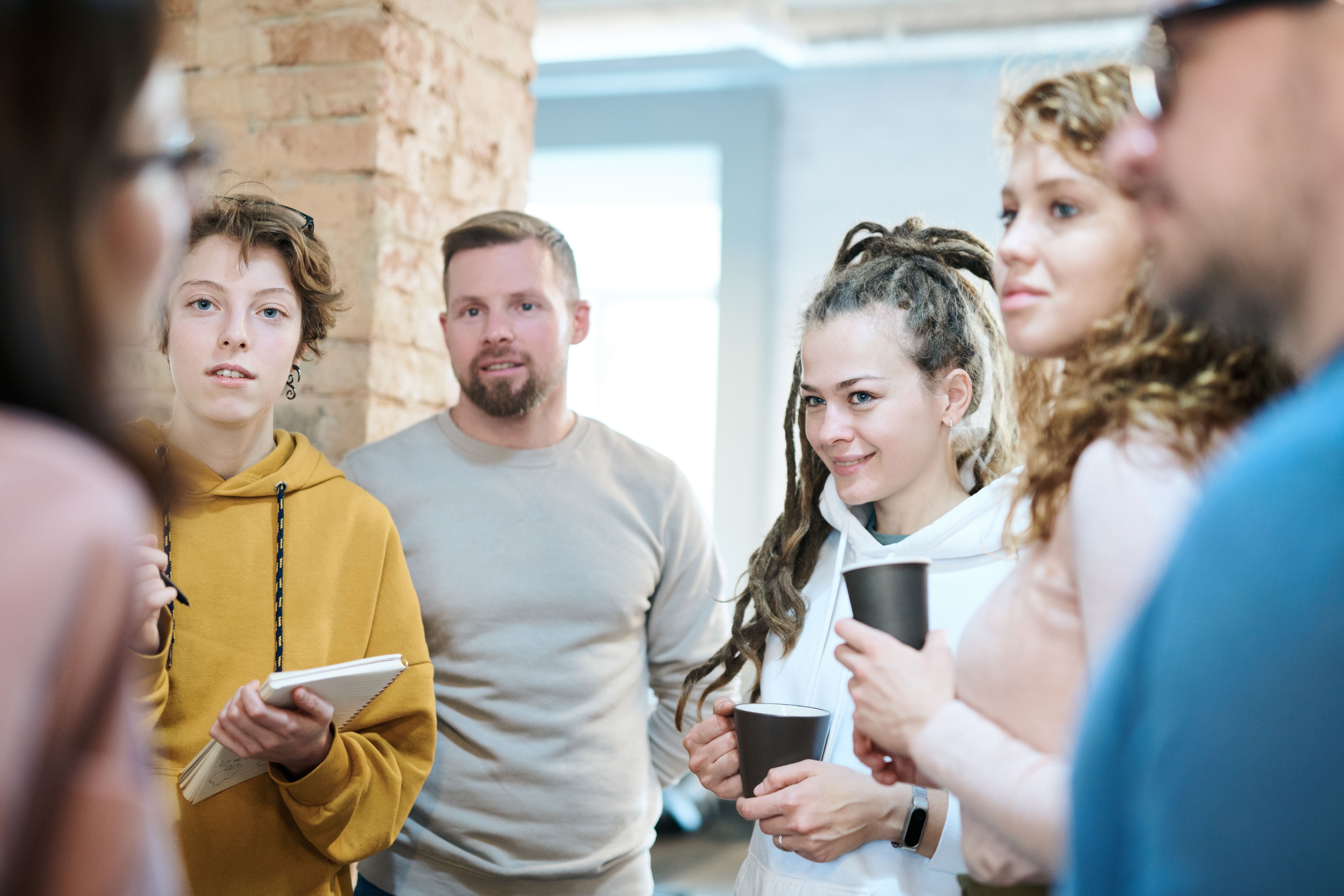 A group of colleagues talking together in a bright, open office